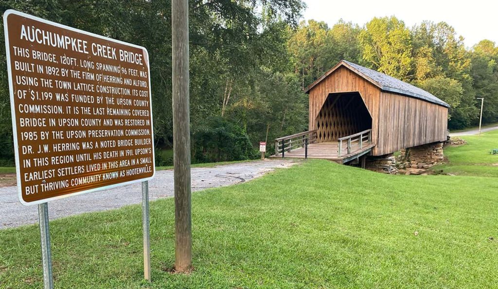 The Auchumpkee covered bridge sign with the bridge in the background.