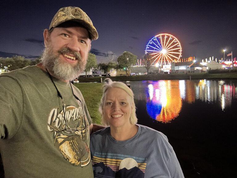 Brian and Tina in front of the ferris wheel at night.